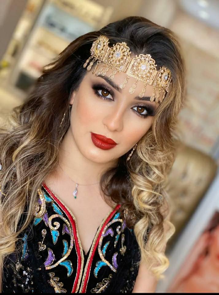 سهيلة بن لشهب بالشعر الكيرلي وأكسسوار ذهبي