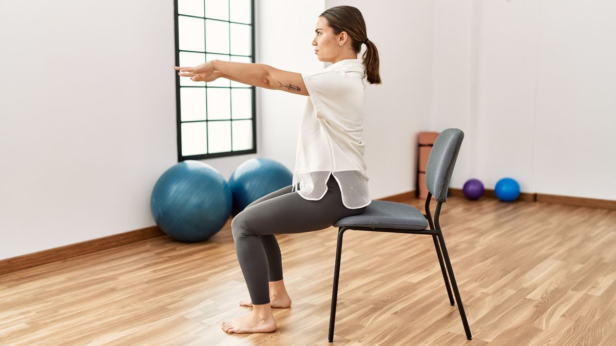 a photo of a woman sitting in a chair doing a chair sit up