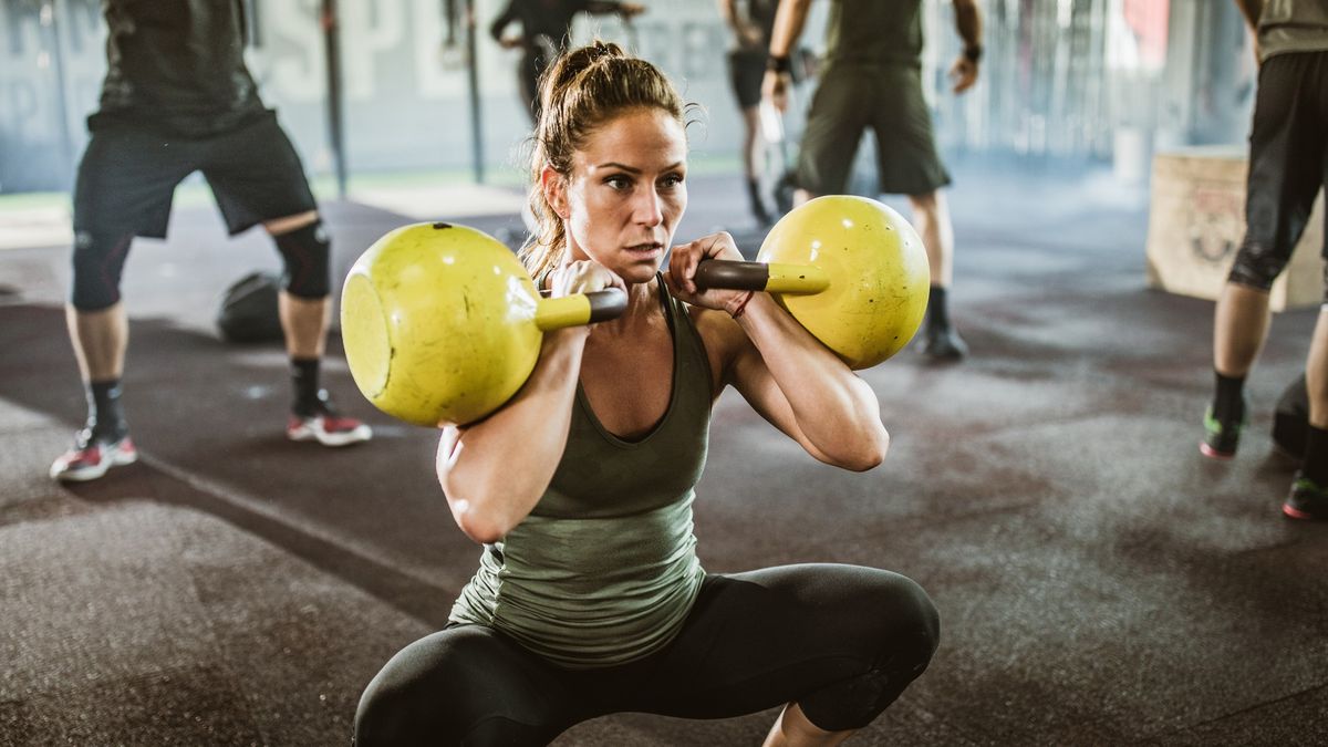 a photo of a woman doing a double kettlebell squat